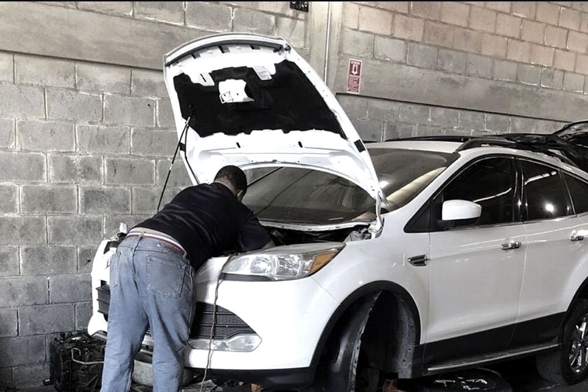 Mecánico trabajando en un vehículo dentro del taller MTCJH